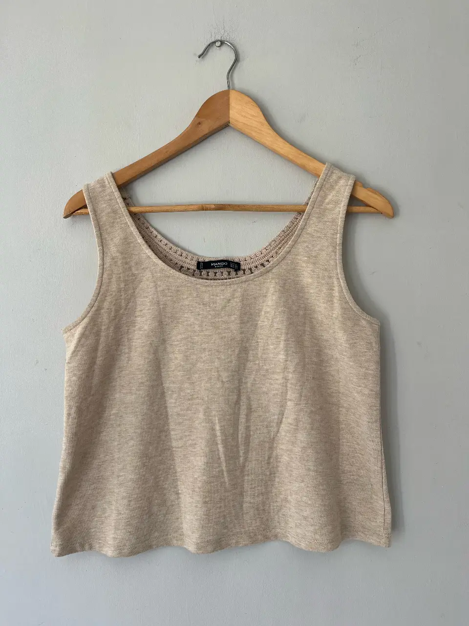 Musculosa de mujer color crudo, con detalle de encaje en la espalda. Ideal para un look casual y fresco.