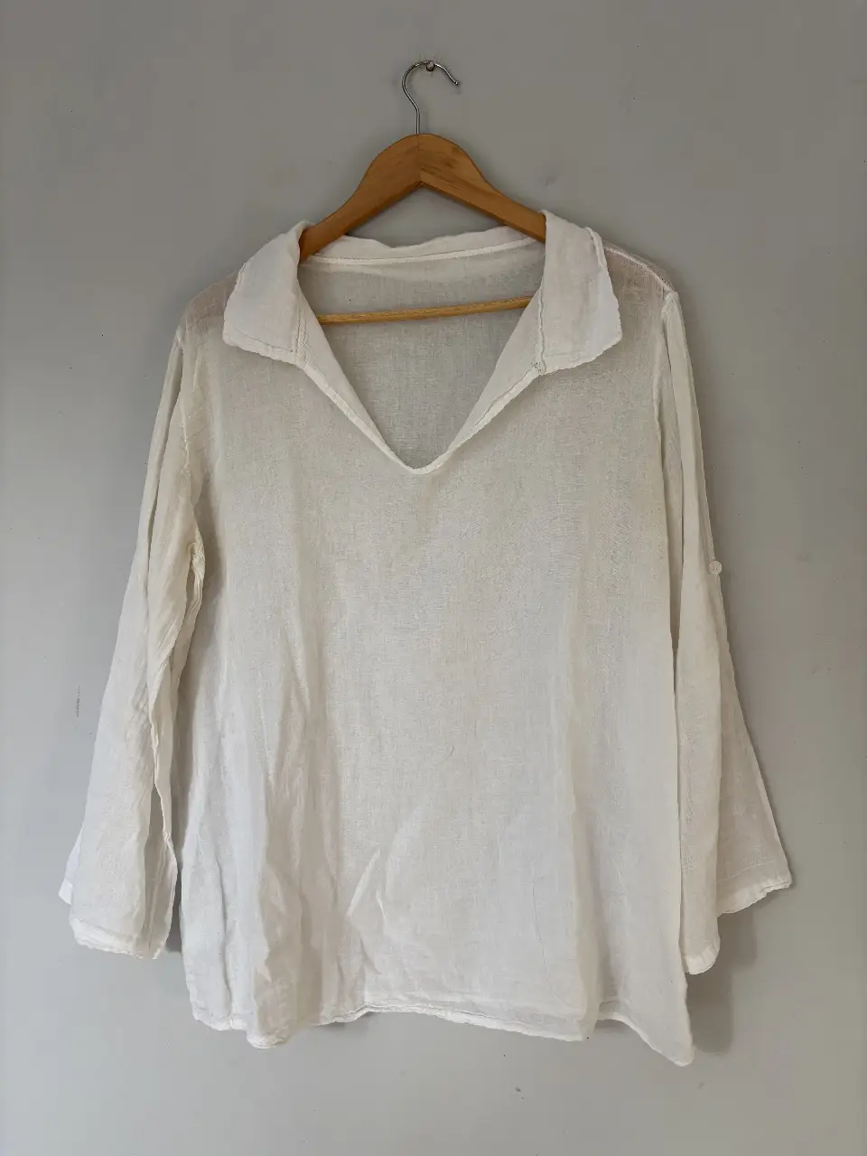 Blusa blanca tipo lino con cuello en V y mangas 3/4. Ideal para un look fresco y casual.
