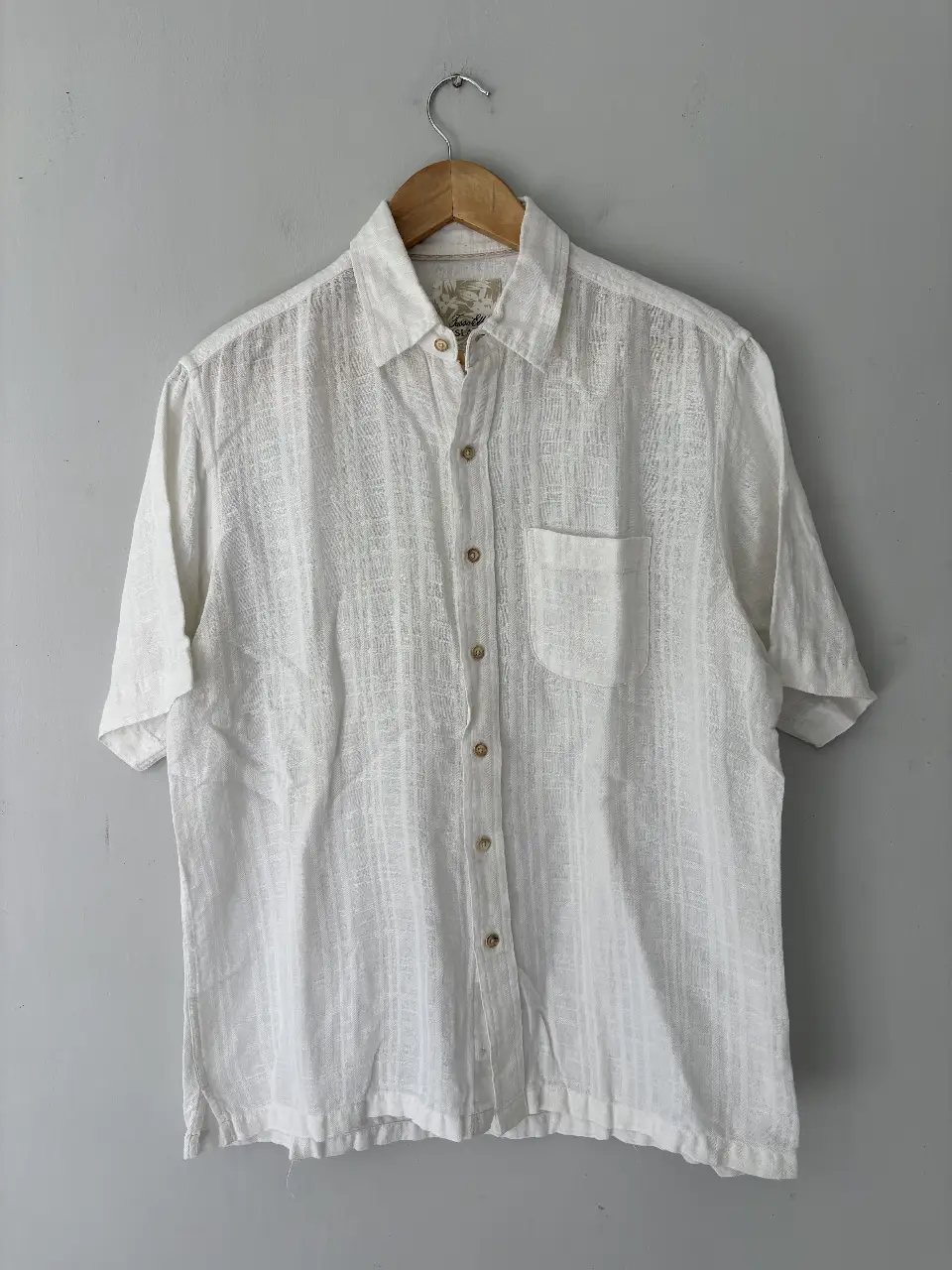 Camisa de hombre de lino blanca con mangas cortas. Ideal para un look casual y fresco en verano. Cuenta con un bolsillo en el pecho y botones.