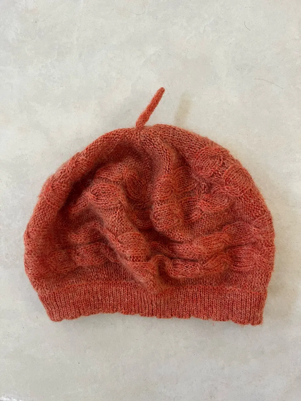 Hermosa boina tejida en color naranja, ideal para complementar tus looks de invierno. Confeccionada en mohair, ofrece calidez y un estilo único.
