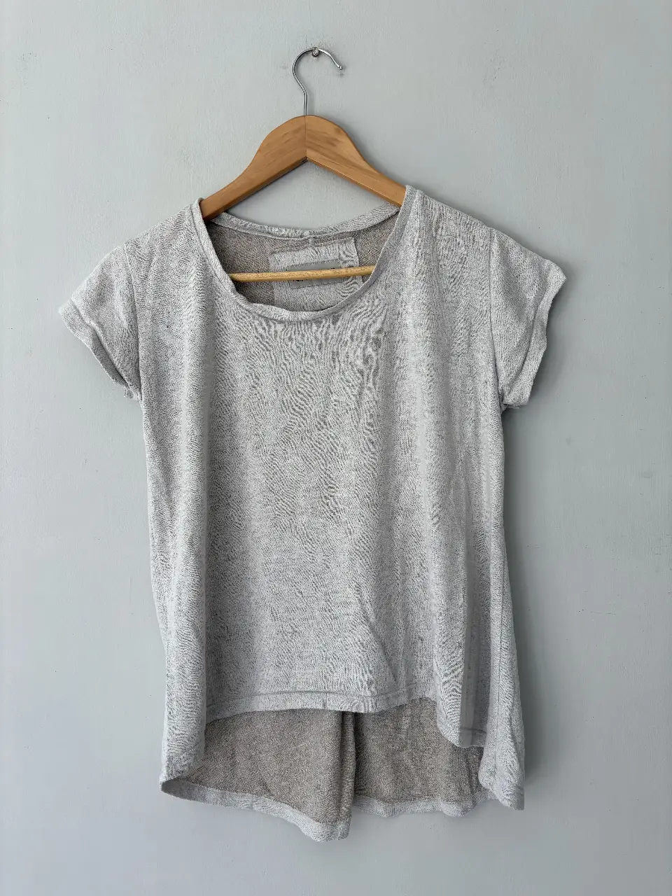 Remera de manga corta gris con un diseño único y detalles de la marca Merci Beaucoup. Ideal para un look casual y moderno.