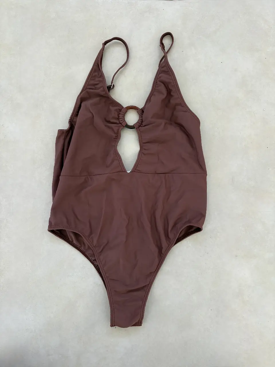 Traje de baño enterizo color marrón con detalle de aro en el centro del busto y abertura. Ideal para lucir en la playa o pileta.