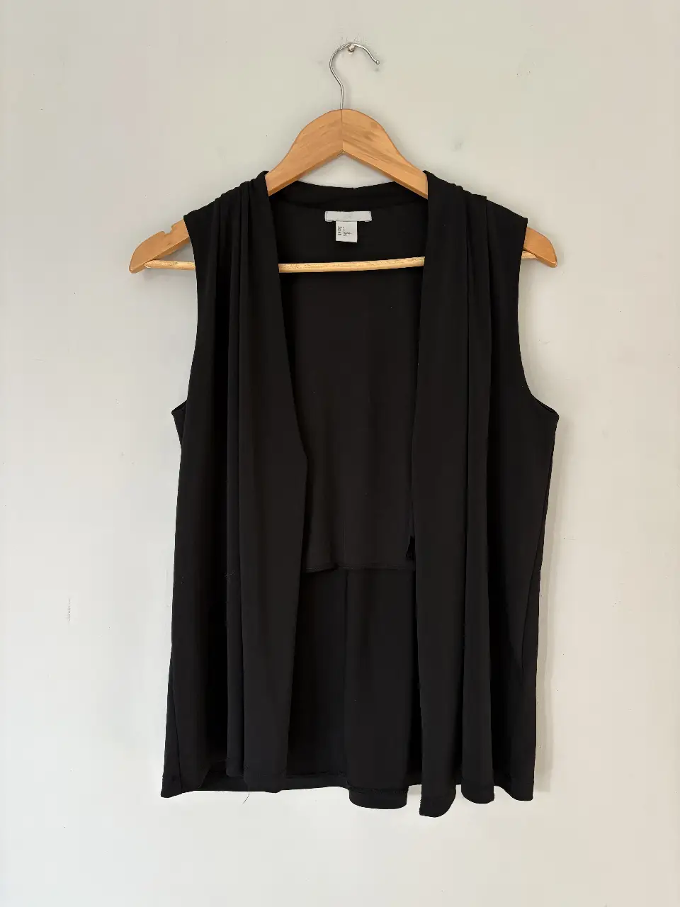 Chaleco negro sin mangas, con diseño abierto y solapas amplias. Ideal para un look elegante y versátil.
