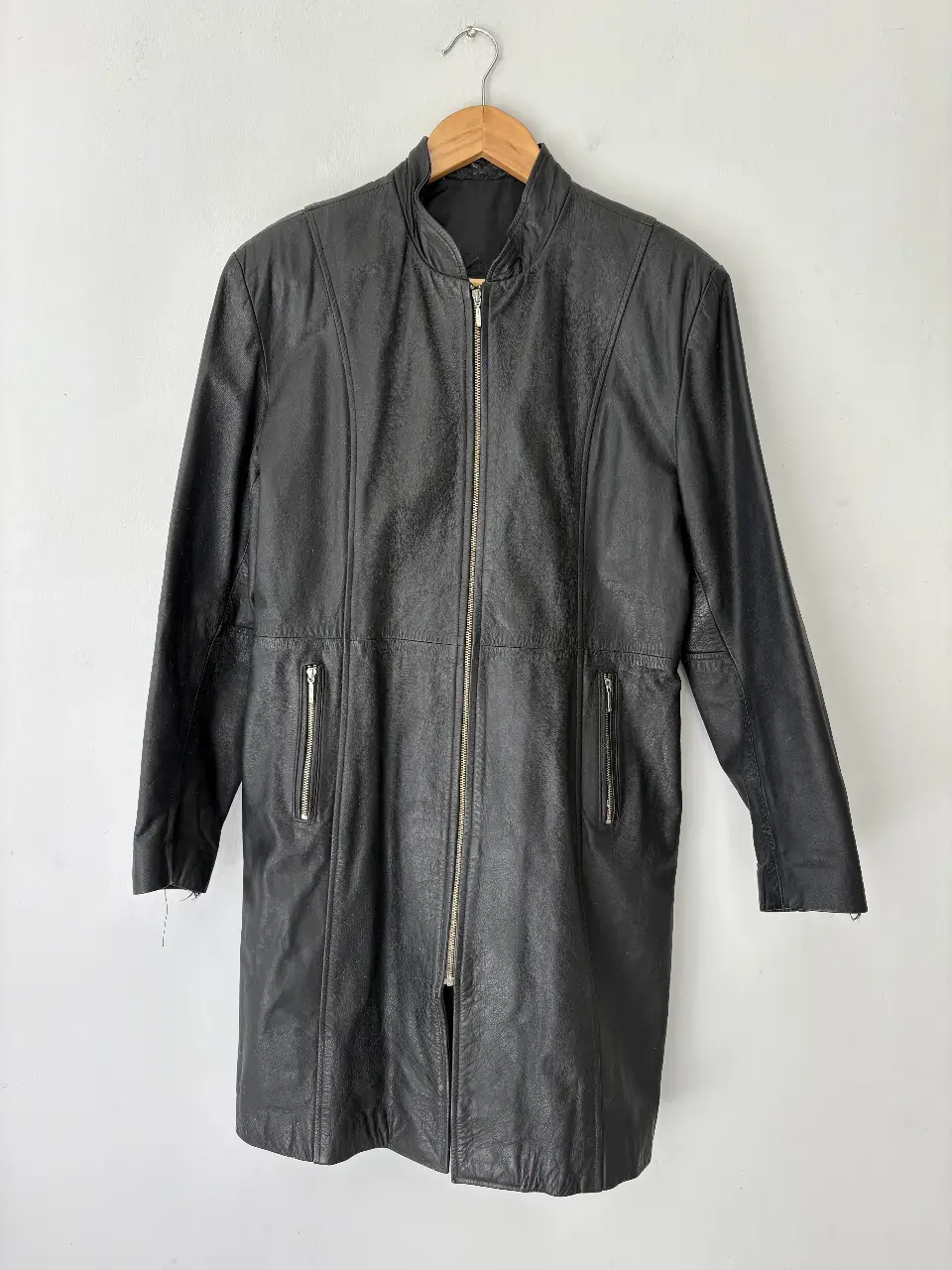 Campera de cuero negra larga, con cierre frontal y bolsillos con cierre. Ideal para un look vintage y canchero.