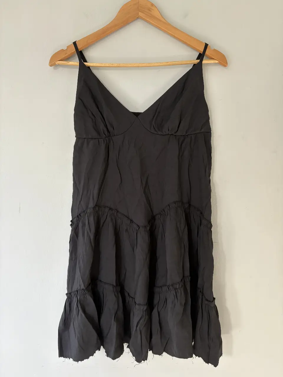 Vestido mini gris oscuro con tirantes finos y diseño escalonado con volados. Ideal para una salida casual o una fiesta.