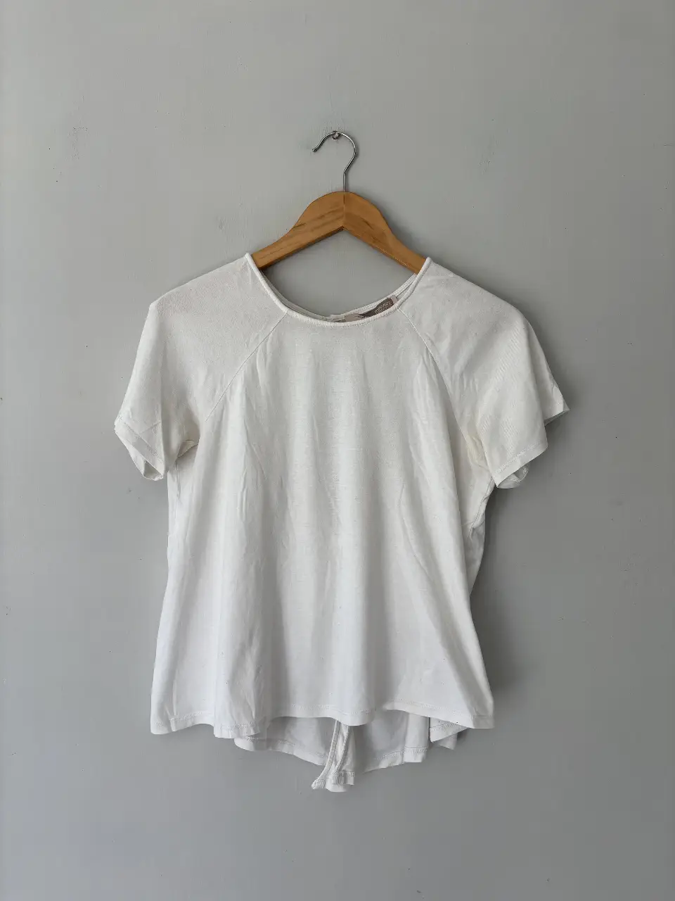 Remera blanca de manga corta con detalle de abertura en la espalda. Ideal para un look casual y fresco.