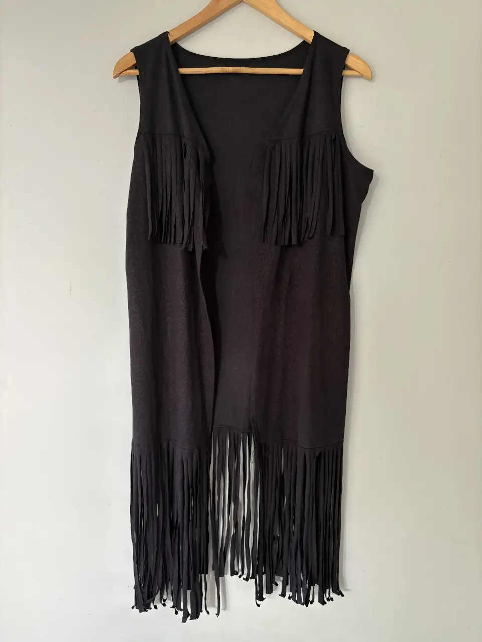 Chaleco negro con flecos, ideal para un look bohemio y moderno. Perfecto para combinar con diferentes outfits.