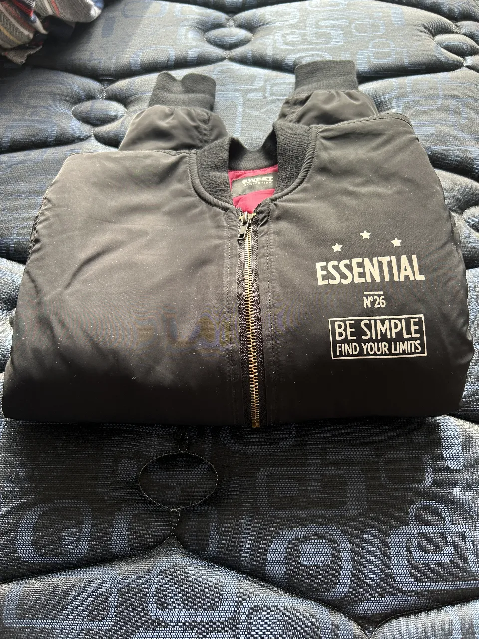Campera bomber negra con detalles en blanco y forro rojo. Ideal para un look casual y urbano. Cuenta con cierre y puños elastizados.