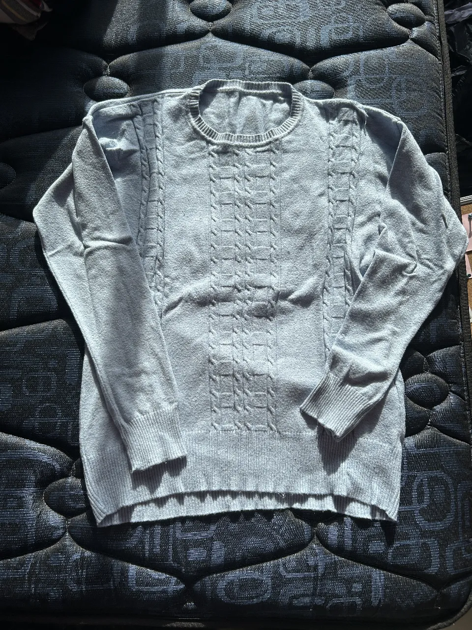 Sweater de hombre de punto, color gris claro con diseño en el frente. Ideal para un look casual y abrigado.