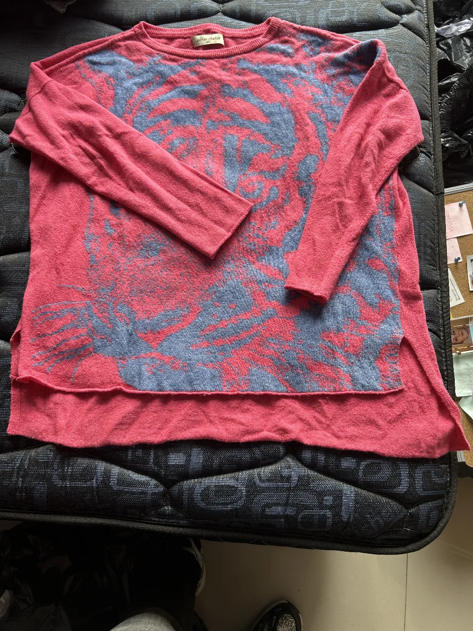 Sweater largo de mujer, color rojo con estampado en azul. Diseño con aberturas laterales y detalle de botón en la manga. Ideal para un look casual y cómodo.
