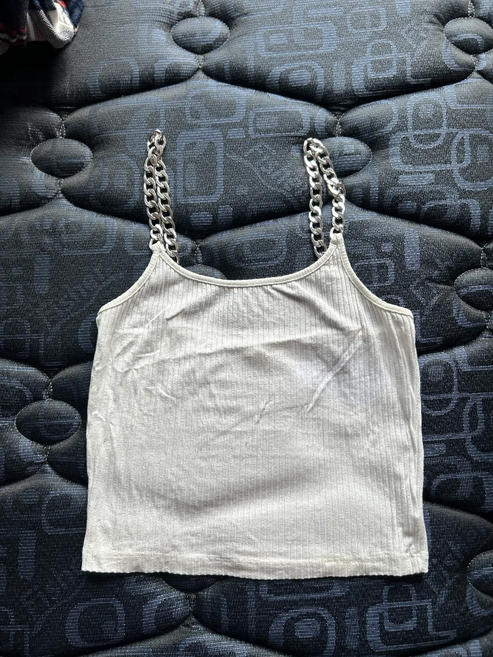 Top de mujer con tiras de cadena plateada. Canchero y moderno, ideal para un look de salida.