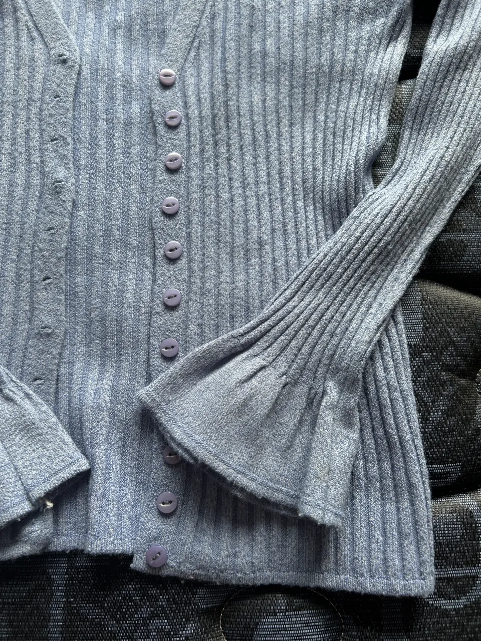Cardigan de punto acanalado en color azul claro, con mangas largas acampanadas y botones frontales. Ideal para un look casual y cómodo.