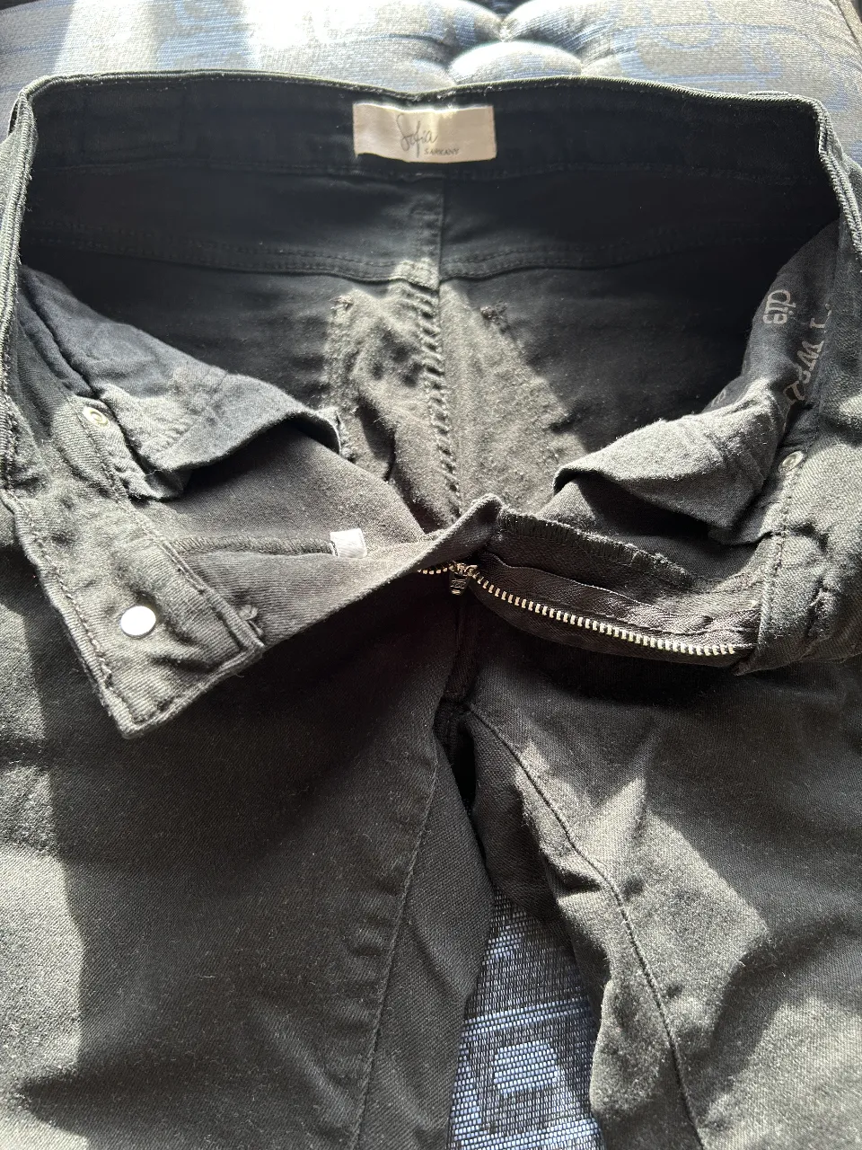 Jeans negro con roturas en las rodillas, tiro medio y corte skinny. Ideal para un look casual y moderno.