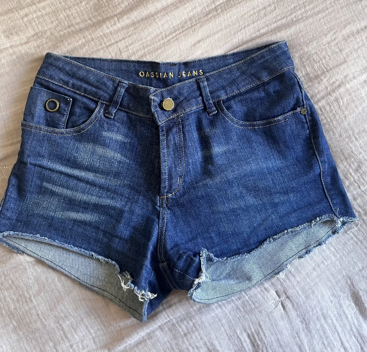 Shorts de jean tiro alto con detalles desflecados en los bordes. Un clásico infaltable para looks casuales y cancheros.
