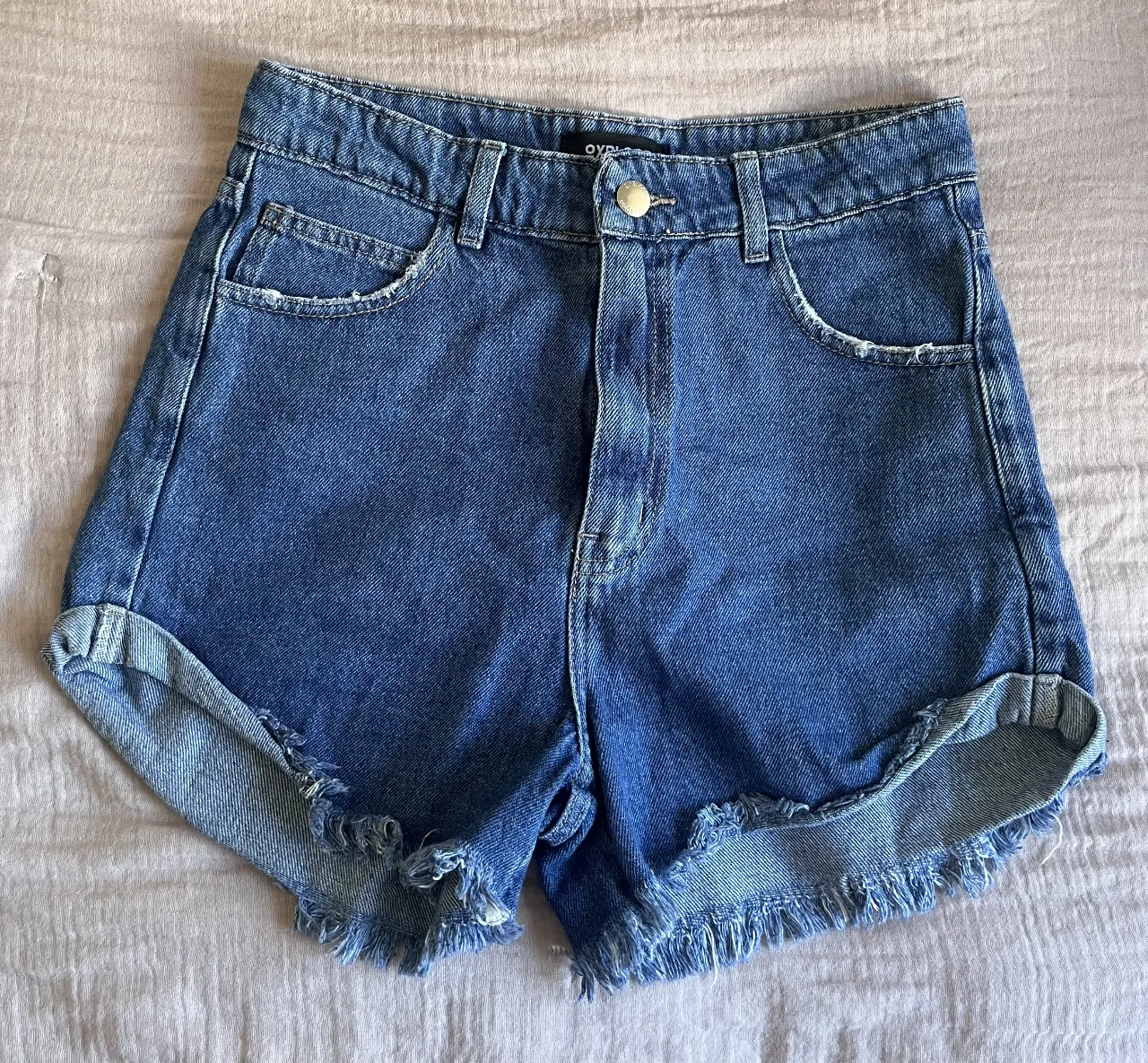 Shorts de jean tiro alto con roturas y ruedo deshilachado. Un clásico infaltable para cualquier guardarropa.