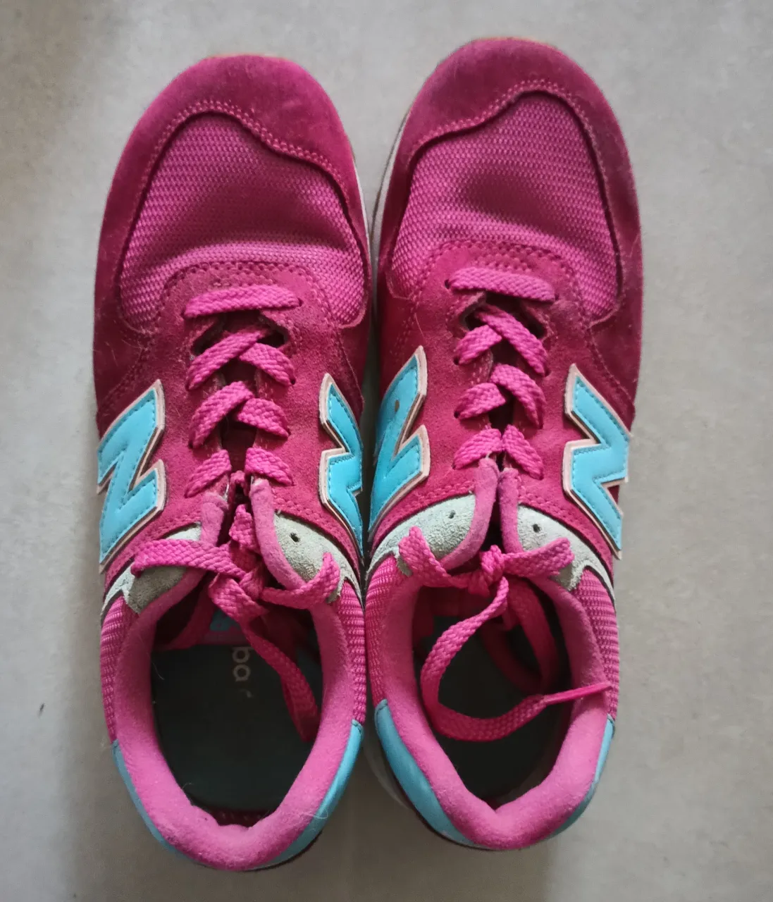 Zapatillas New Balance 574 fucsia con detalles en celeste
