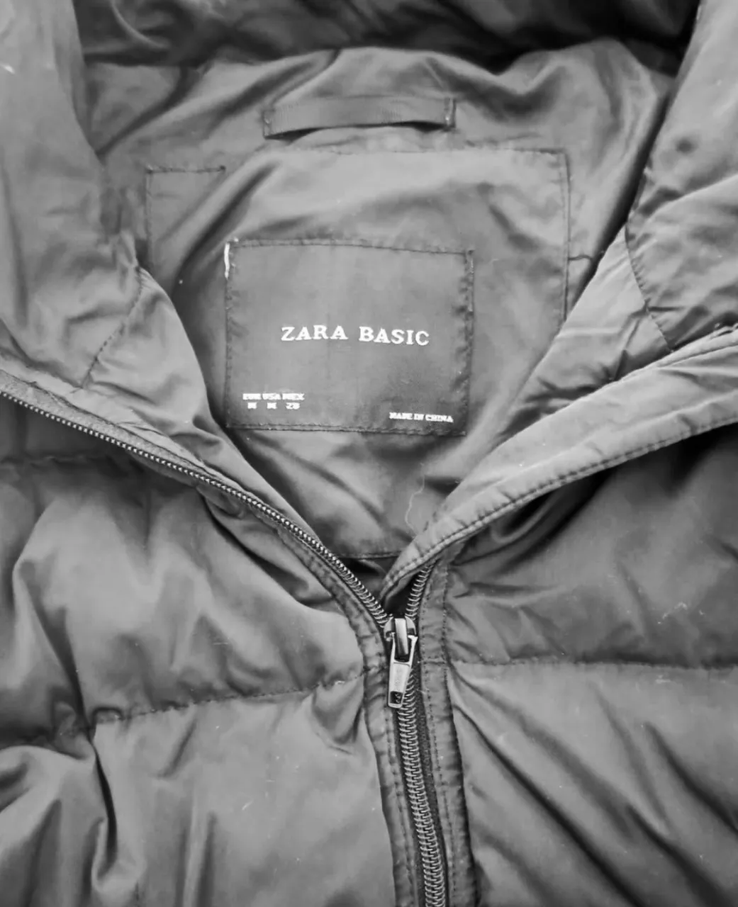 Camperón de pluma Zara Basic, color negro, con cierre y bolsillos con cierre dorado.