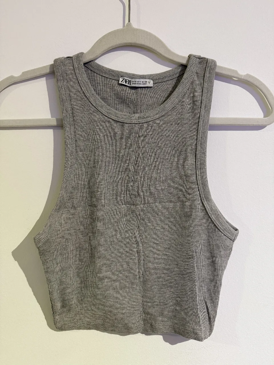 Top de mujer de tejido de punto acanalado, sin mangas y cuello redondo. Ideal para un look casual y moderno. 