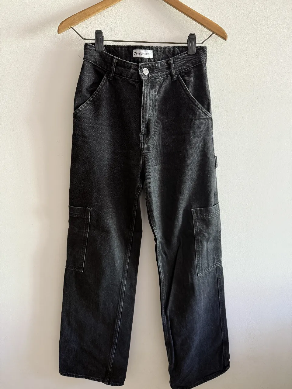 Pantalón cargo de jean negro, tiro alto, con bolsillos laterales y traseros. Ideal para un look casual y moderno.