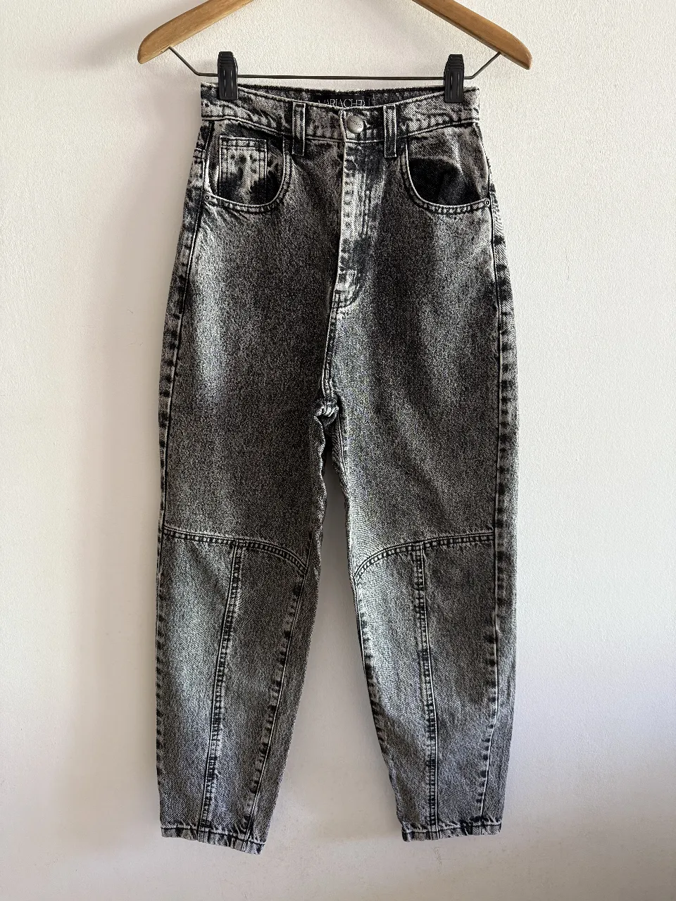 Jeans de mujer tiro alto, con un diseño acid wash en color gris. Corte recto y detalles en las rodillas. Ideal para un look casual y moderno.