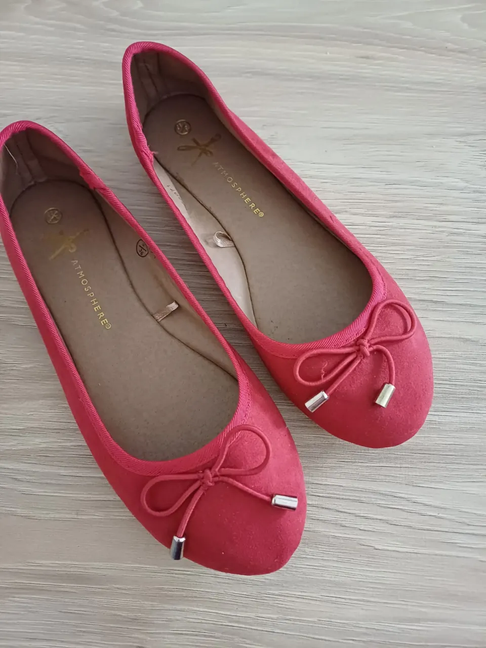 Ballerinas rojas de gamuza con moño y detalles plateados. Ideales para un look casual y femenino.