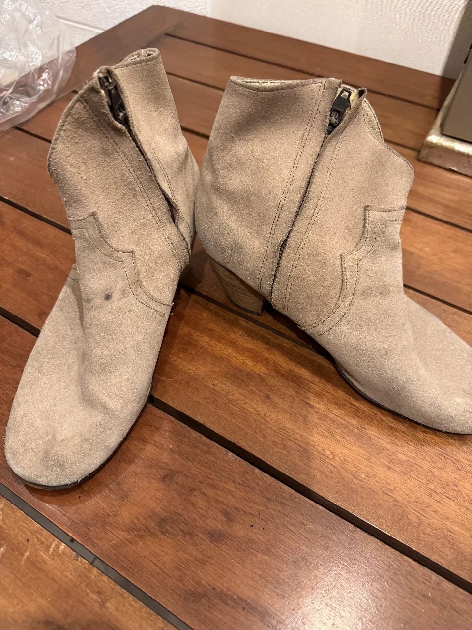 Botines de gamuza color marrón claro, con cierre lateral y detalles de diseño en el frente. Ideales para un look casual y cómodo.