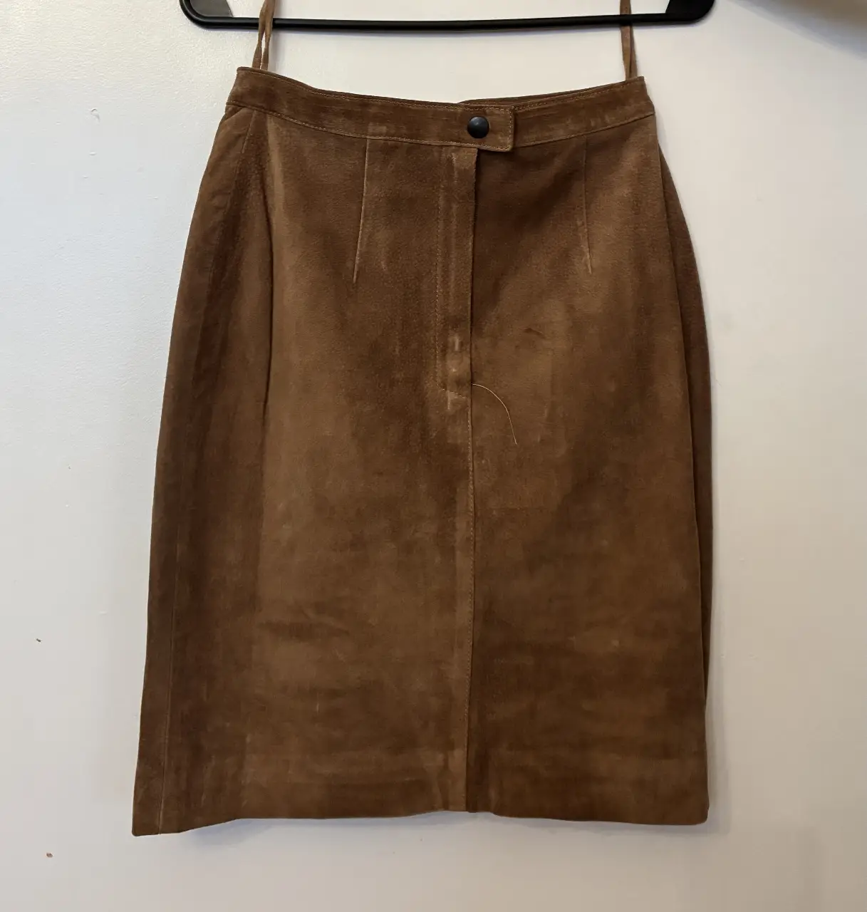 Pollera de gamuza marrón, con cierre y botón. Ideal para un look vintage y elegante. Talle 1, largo 51cm, forro interno