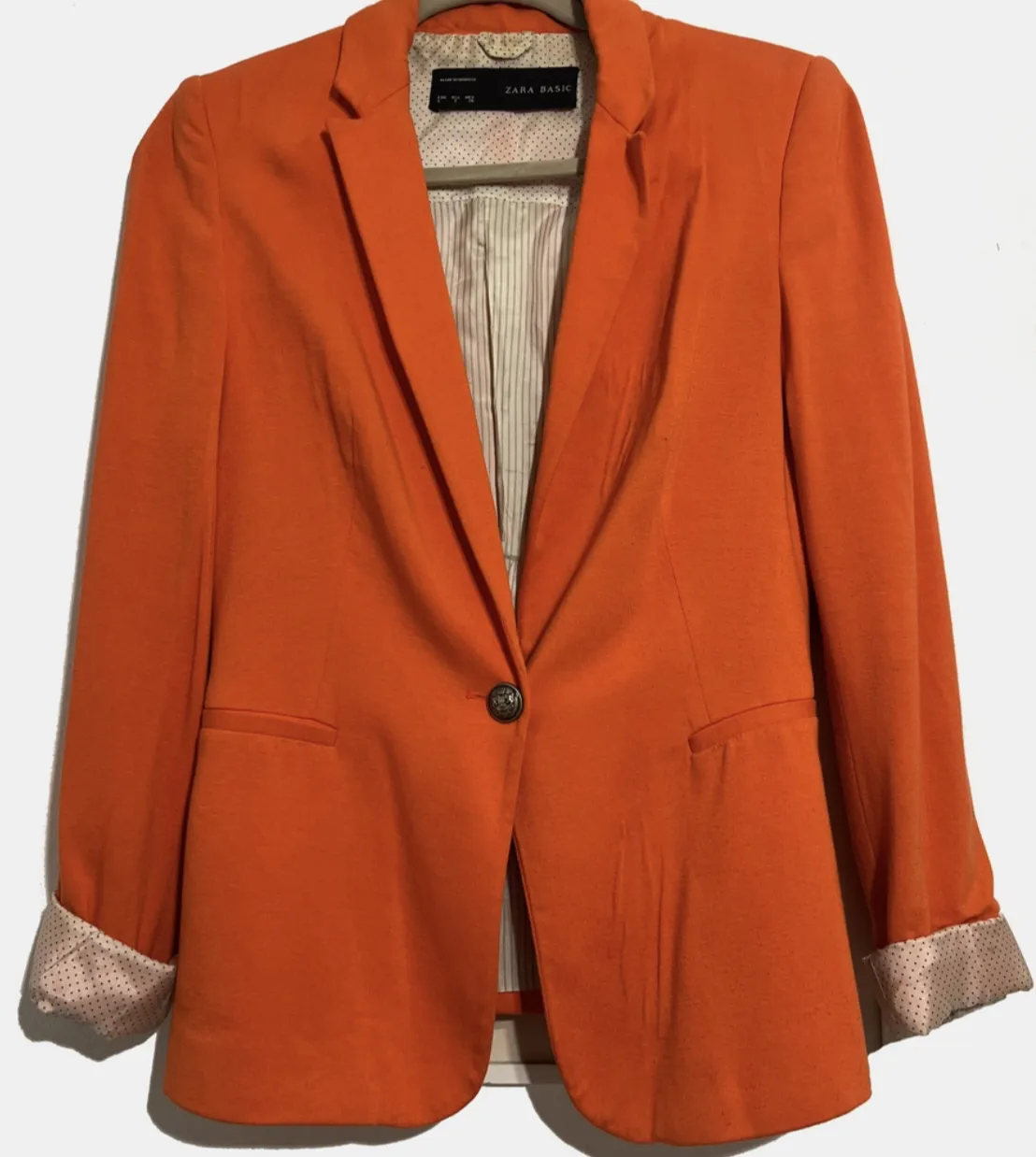 Blazer naranja de mujer, de la marca Zara Basic. Corte clásico con un solo botón y solapas. Ideal para un look elegante y moderno. Es de verano