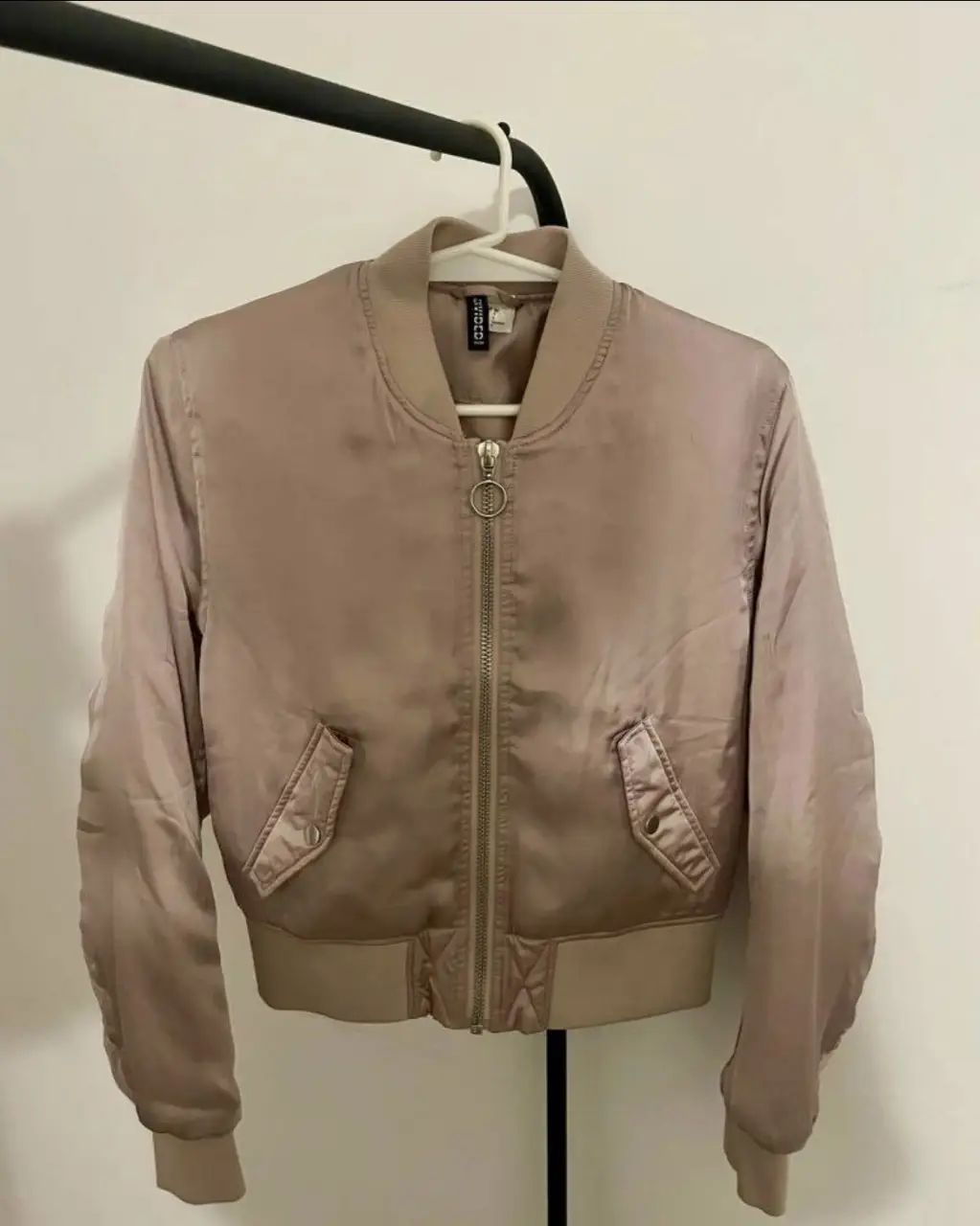 Campera bomber de satén color rosa, con cierre frontal y bolsillos. Ideal para un look casual y moderno.