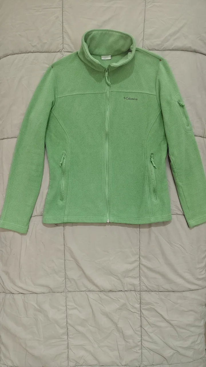 Campera de polar verde vibrante, ideal para actividades al aire libre o para un look casual y cómodo. Con cierre completo y bolsillos con cierre, es práctica y funcional. Perfecta para los días frescos de entretiempo o como capa adicional en invierno.
