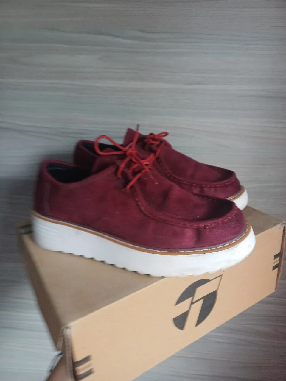 Zapatos de gamuza color bordó con cordones y suela blanca. Ideales para un look casual y moderno.