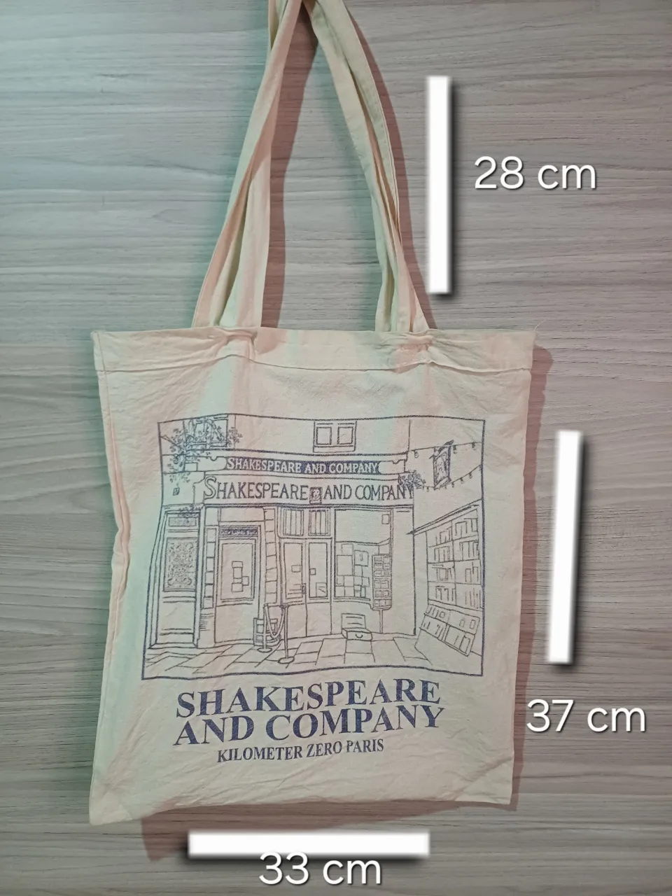 tote bag color crudo con estampa de "Shakespeare and Company" Medidas: 33 cm de ancho, 37 cm de alto y 28 cm de las asas.
