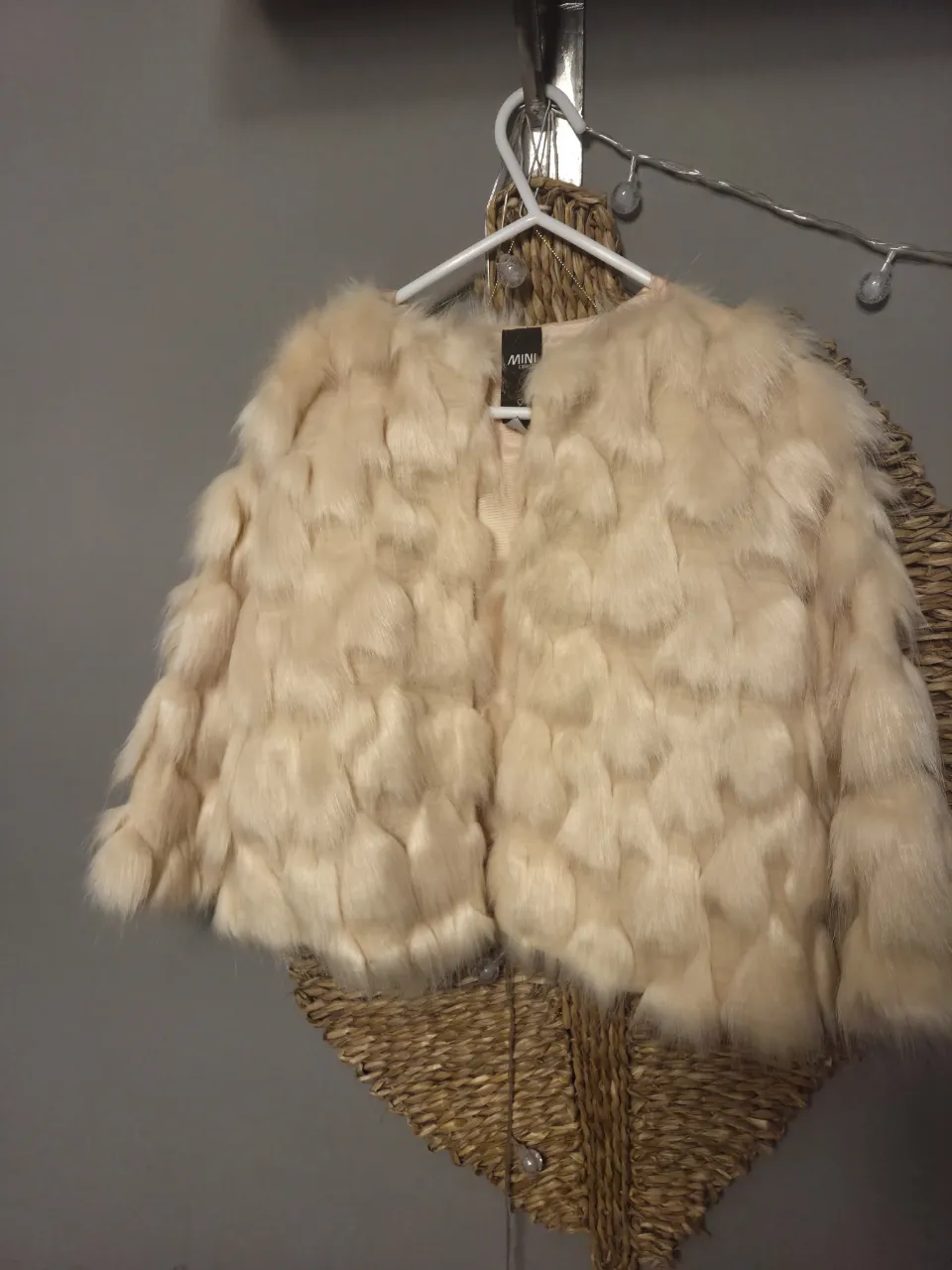 Campera de pelo sintético color crema. Posee cuello redondo y mangas largas.