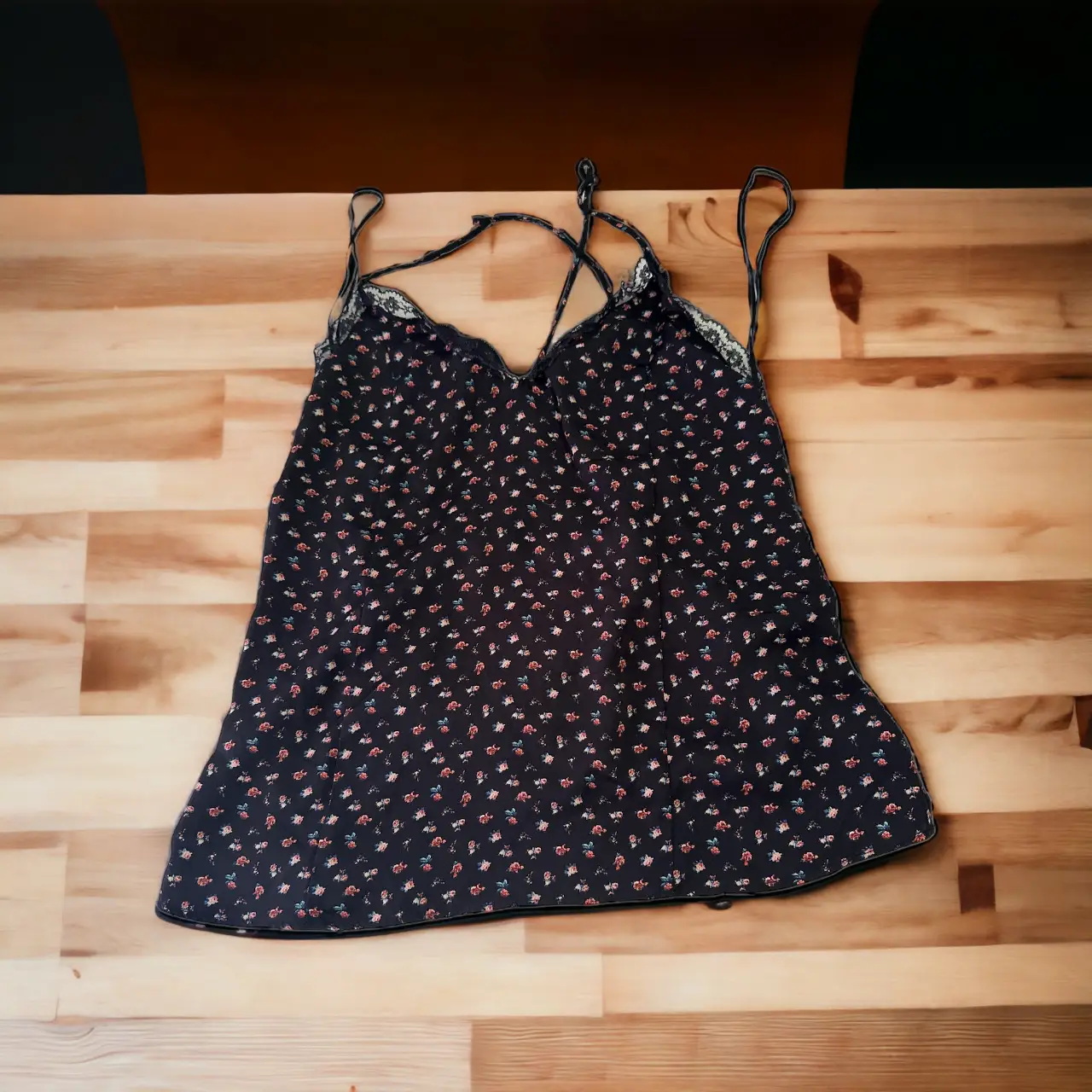 Top negro con estampado floral, ideal para un look fresco y femenino. Perfecto para combinar con jeans o faldas.