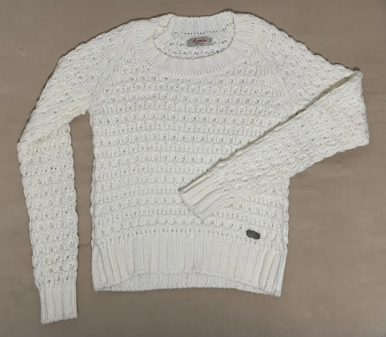 Sweater blanco tejido, ideal para un look casual y abrigado. Perfecto para combinar con jeans o pantalones de vestir.