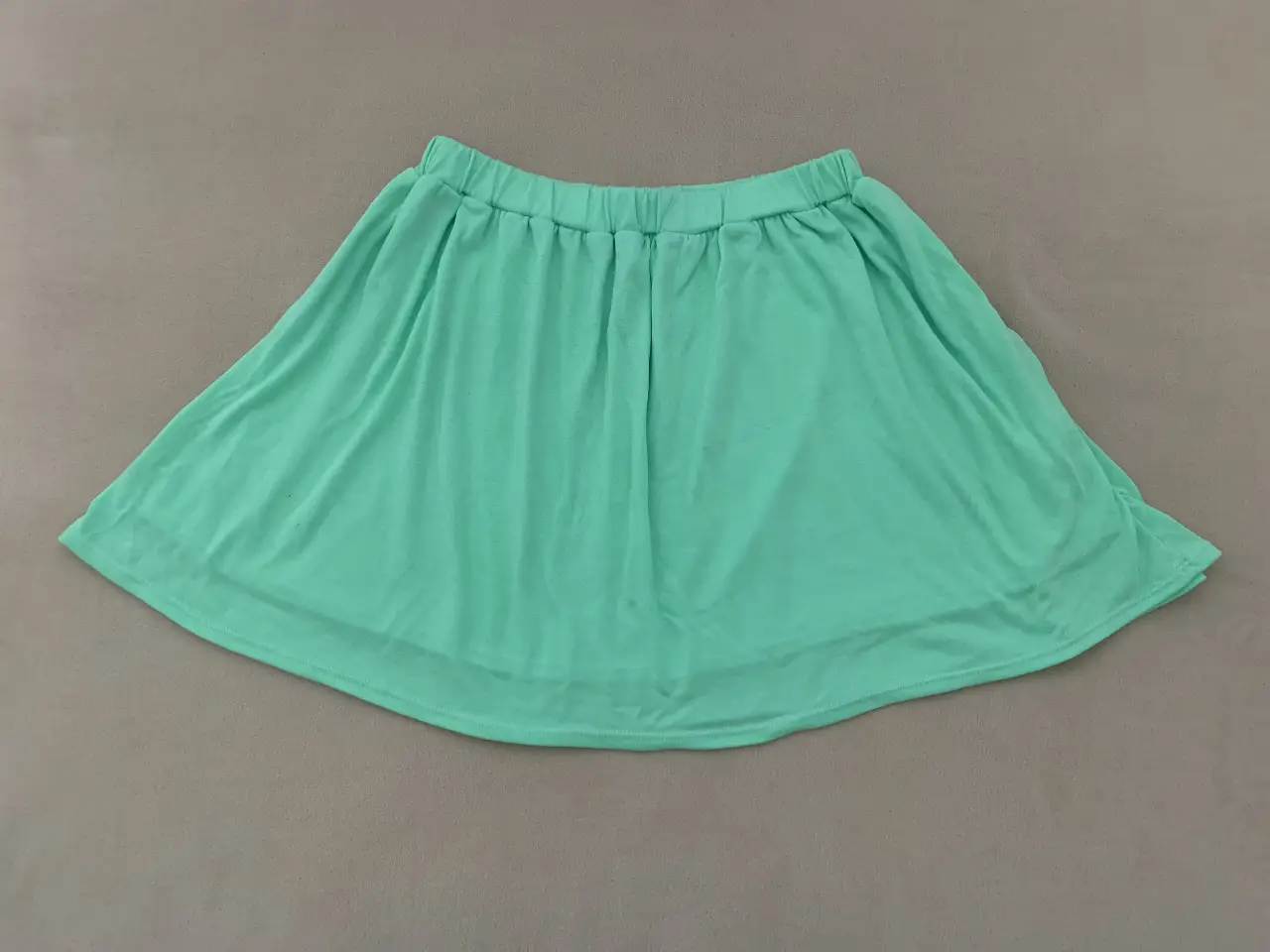 Pollera corta de color verde, ideal para un look casual y fresco. Confeccionada en tela suave y cómoda, perfecta para el verano.