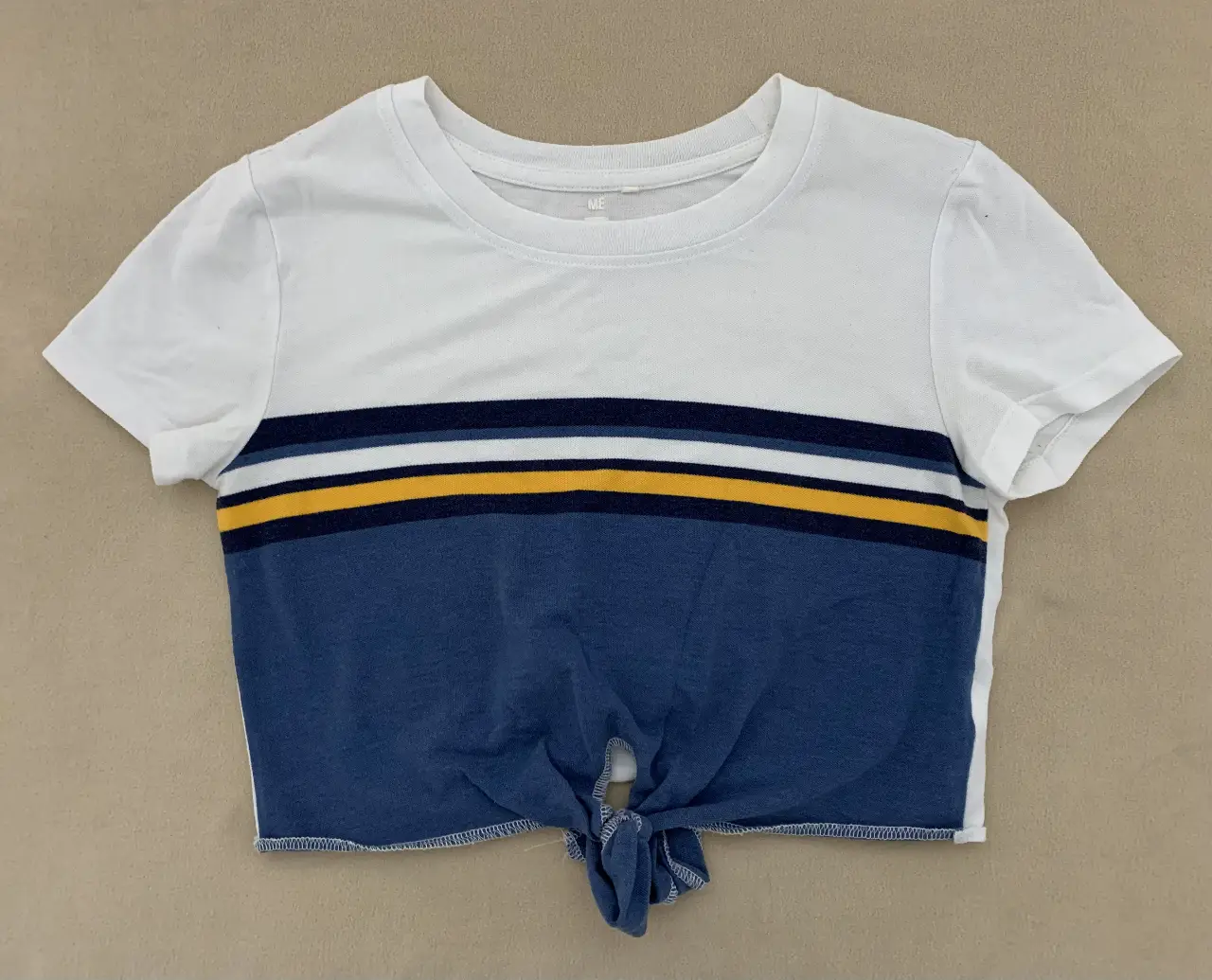 Top corto de mujer con diseño a rayas en el frente y nudo en la parte inferior. Ideal para un look casual y moderno.