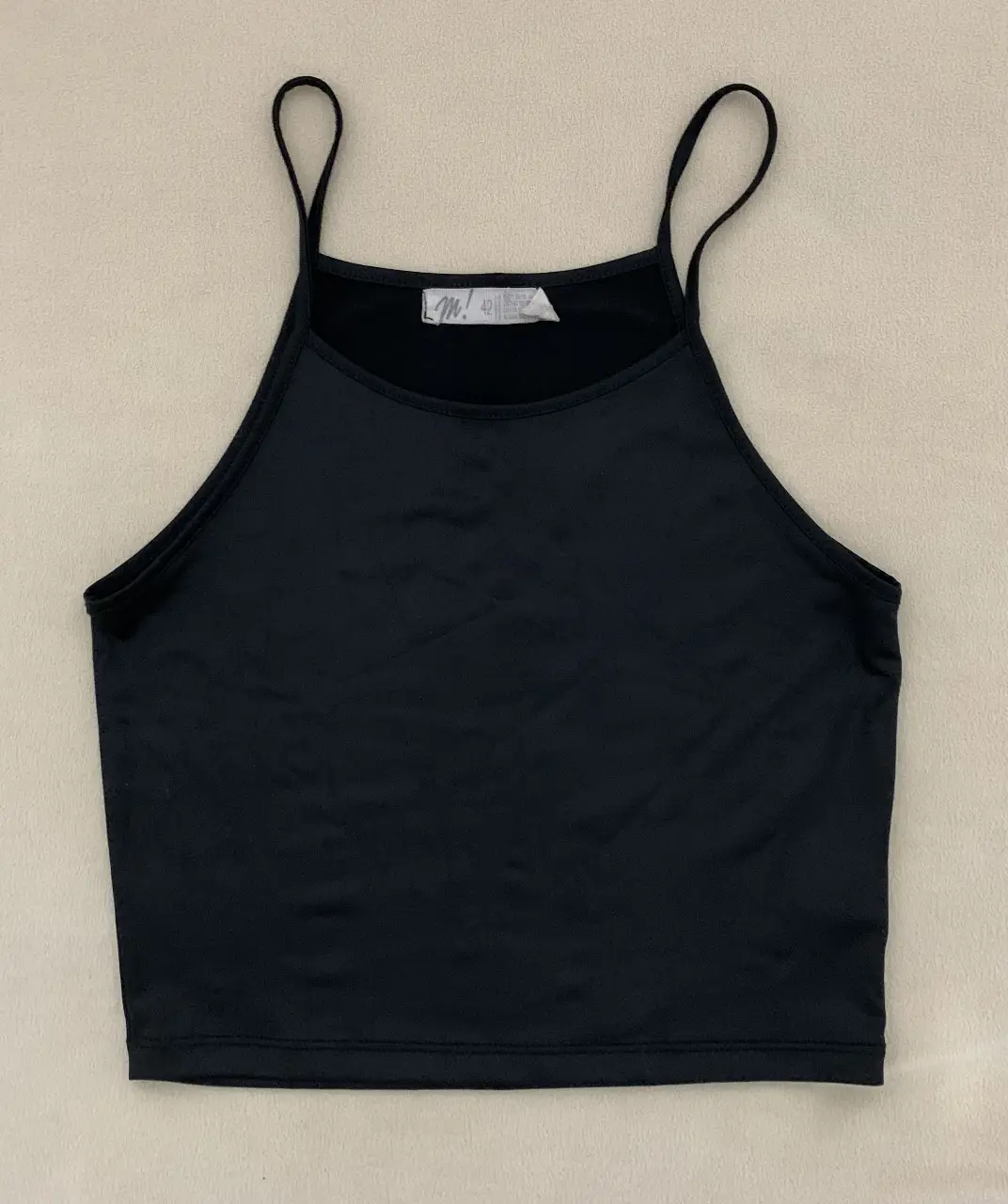 Top negro con breteles finos, ideal para combinar con cualquier outfit. Perfecto para un look casual.