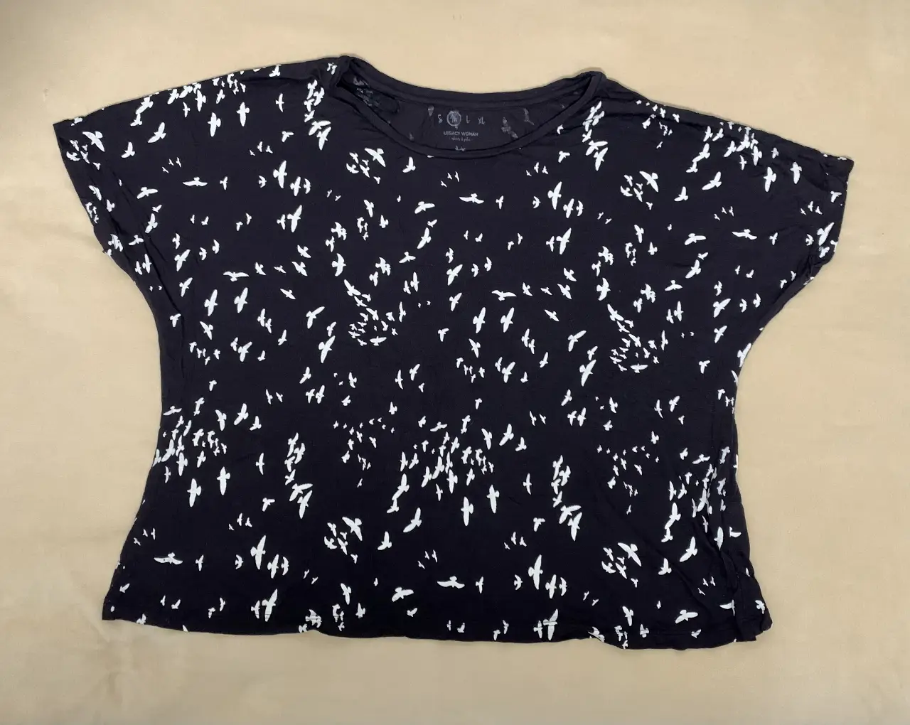 Remera de mujer negra con estampado de pájaros blancos. Corte holgado y cuello redondo. Ideal para un look casual y cómodo.