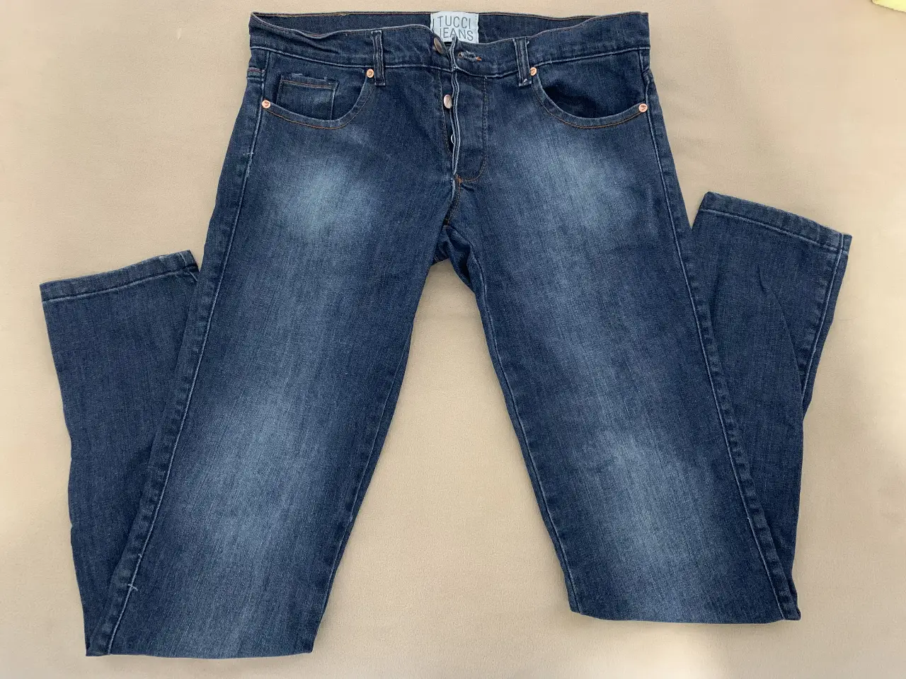 Jeans rectos de mujer, color azul oscuro, con detalles de costura en naranja. Marca Tucci Jeans. 