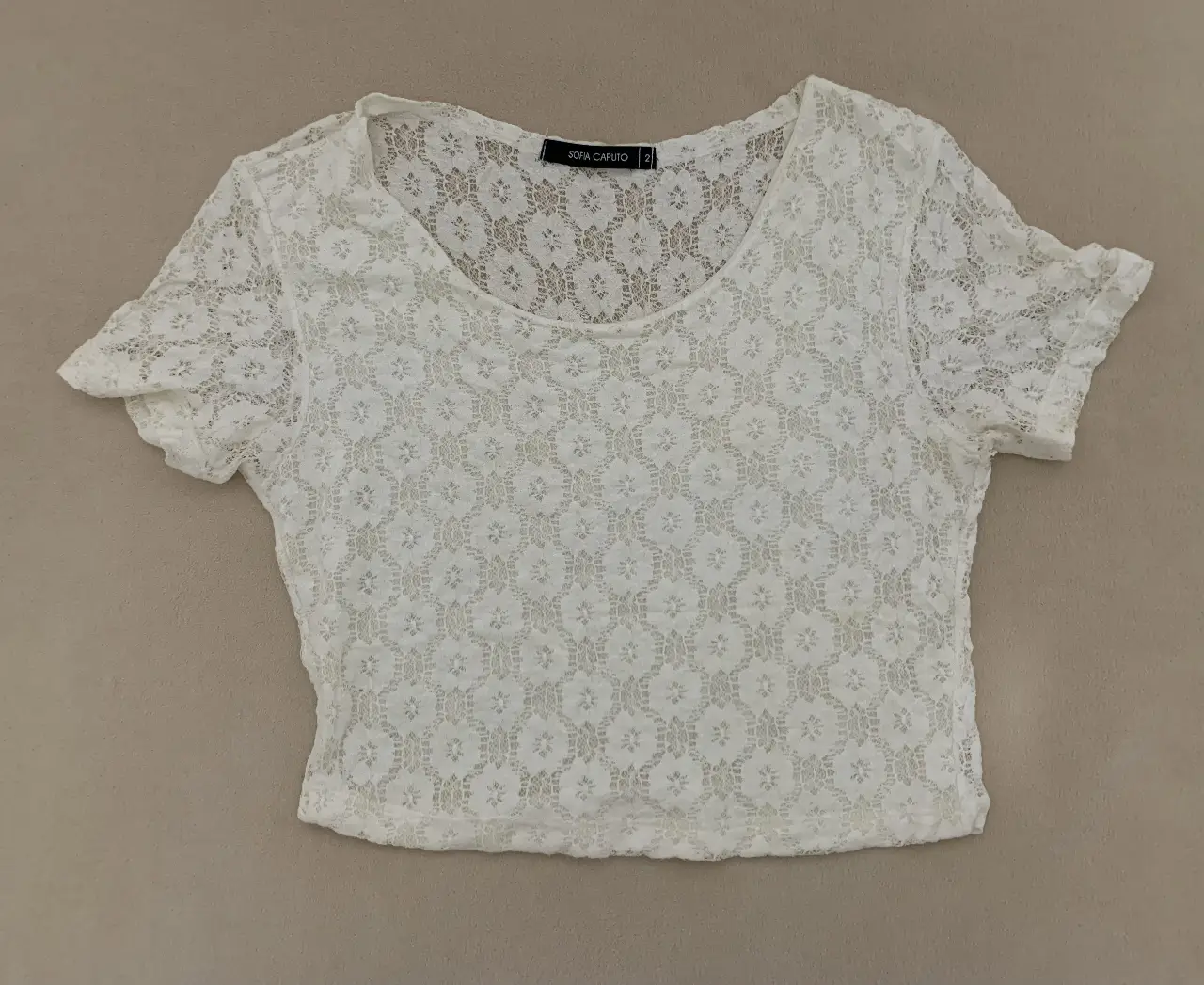 Blusa de encaje blanca, ideal para un look romántico y delicado. Perfecta para combinar con jeans o faldas. Espalda traslúcida.
