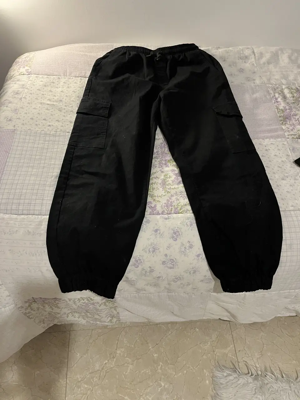 Pantalón cargo negro de hombre, con bolsillos laterales y ajuste en los tobillos. Ideal para un look casual y urbano.