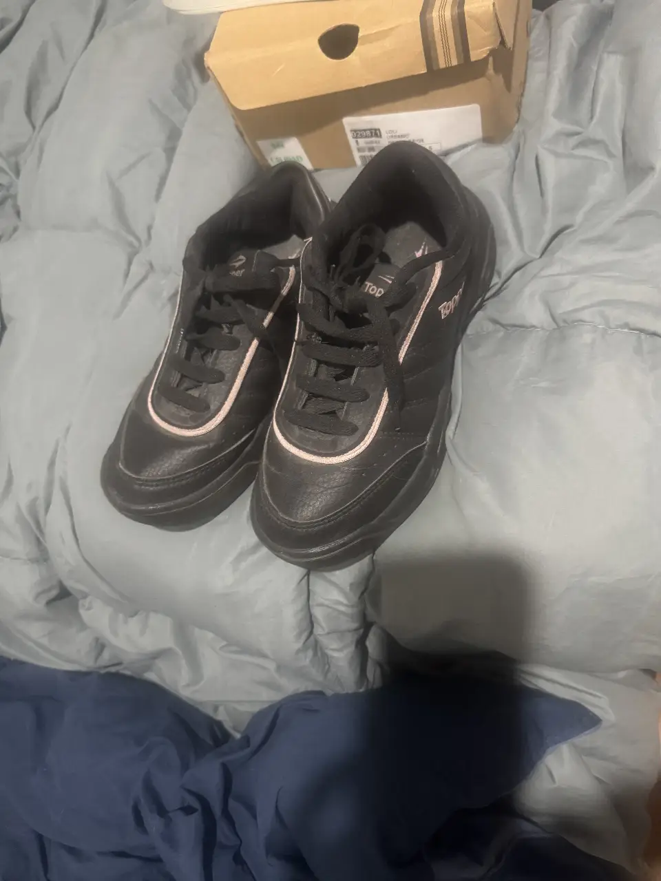 Zapatillas negras de cuero sintético con detalles en rosa, ideales para uso diario y actividades deportivas.