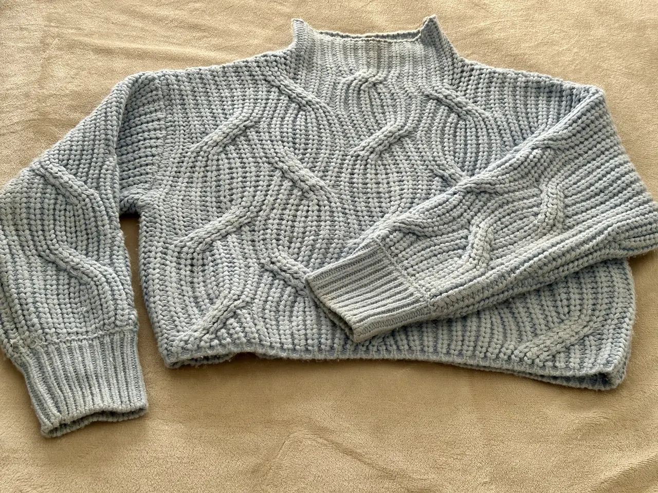 Sweater de mujer tejido en punto trenzado, con cuello alto y mangas largas. Ideal para un look casual y abrigado.