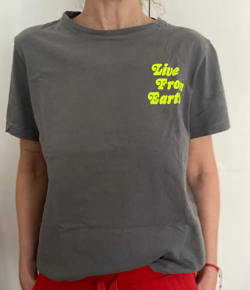 Remera gris con estampado "Live From Earth"  Ideal para un look casual y cómodo.