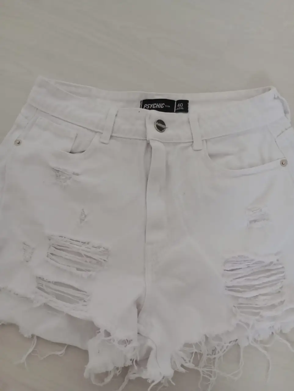 Short de jean blanco con roturas y detalles desflecados. Talle 40. Ideal para un look casual y moderno.