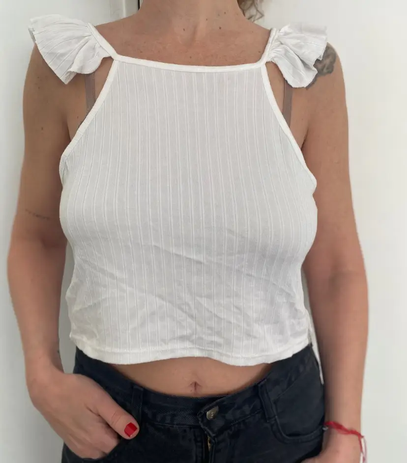 Top blanco con detalle de volados en los hombros y espalda descubierta. Ideal para un look fresco y moderno.