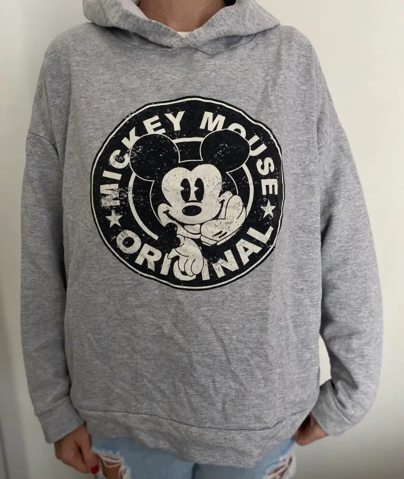 Buzo canguro gris con estampado de Mickey Mouse original en el frente. Ideal para un look casual y cómodo.