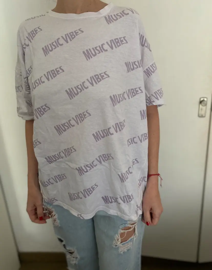 Remera MARCA BUDDIES de mujer blanca con estampado "MUSIC VIBES" en color lila. Ideal para un look casual y relajado. Perfecta para combinar con jeans.