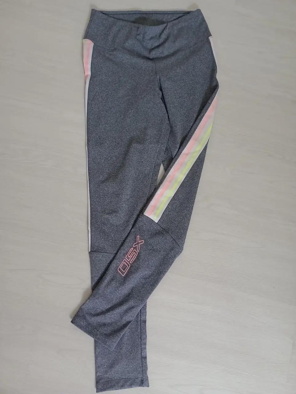 Calzas deportivas grises con detalles en rosa y amarillo. Talle M. Ideal para running y actividades de gimnasio.